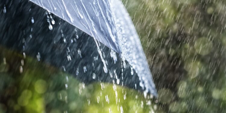 Rain drops falling from a black umbrella concept for bad weather, winter or protection